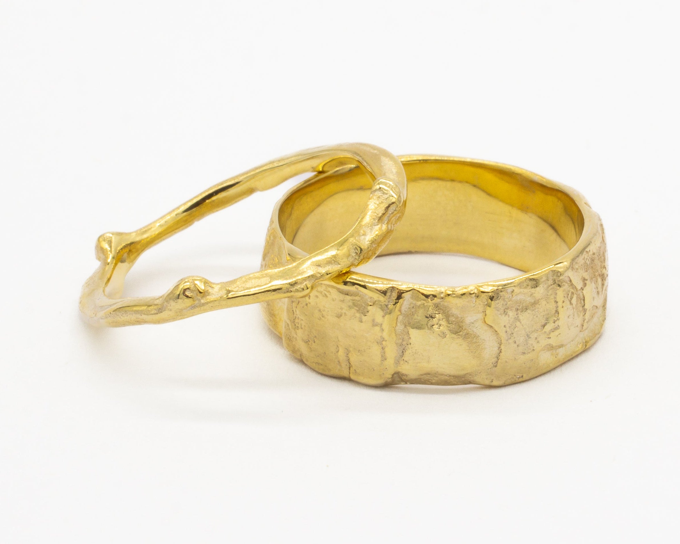 Gold ring with a textured design on a white background