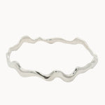 Silver bangle with wavy design on a white background