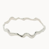 Silver bangle with wavy design on a white background