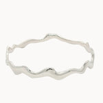 Silver bangle with wavy design on a white background