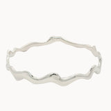 Silver bangle with wavy design on a white background