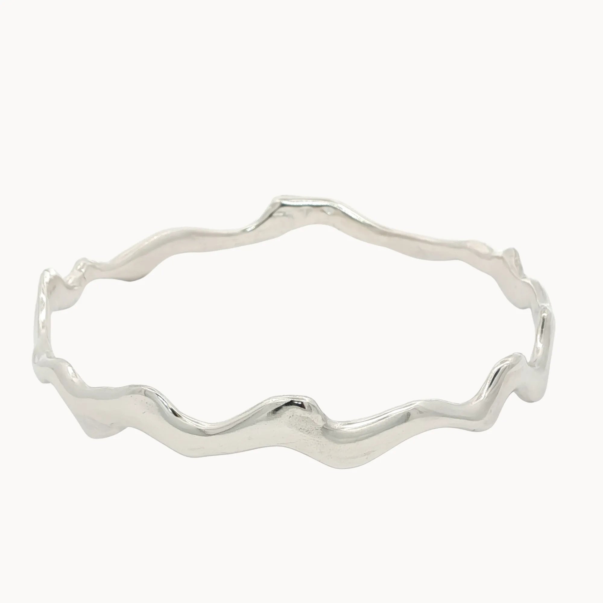 Silver bangle with wavy design on a white background