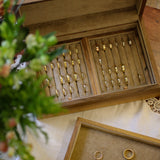 Wooden jewelry box with gold rings on a wooden surface with flowers.