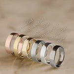 6 gold wedding rings in various colors on a beige background