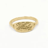 solid gold word ring engraved with 'Worthy' in script font on a white background