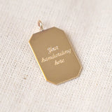 Gold pendant with 'Your handwriting here' text on a textured beige background